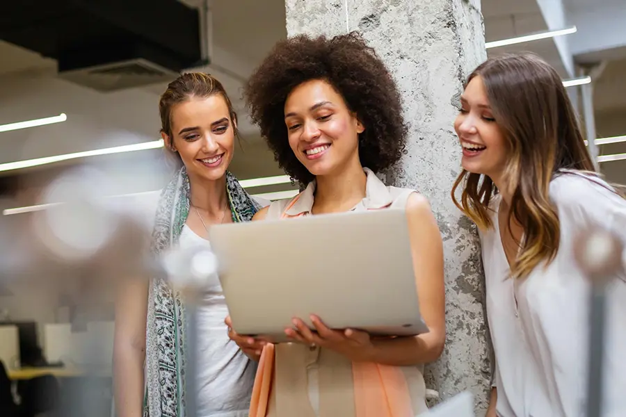 Drei Frauen im Büro lernen mit Blick auf ein Notebook